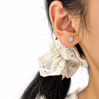 The Neva CZ Stud Earrings — warm gold-tone on-ear view in a white studio; studio edit and AI enhancement of the existing AI-enhanced supplier view.