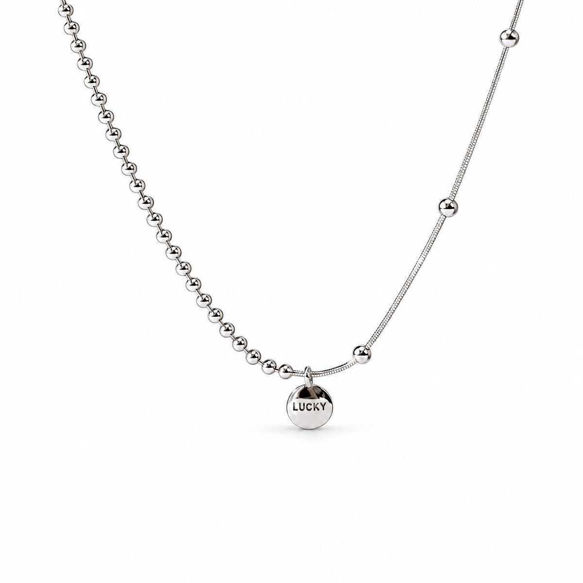 Sterling Silver Eira necklace with round LUCKY medallion, beaded and smooth chain sections, in the existing cropped tabletop view with white studio treatment and soft shadow; AI studio edit and enhancement of the existing supplier source view; chain ends extend beyond the frame.