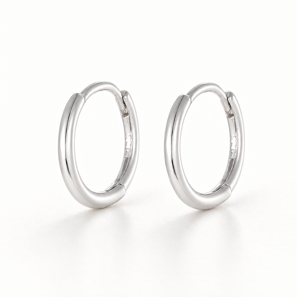 The Kiri Huggie Hoops — Silver pair — upright three-quarter studio view; reference-based AI visualization