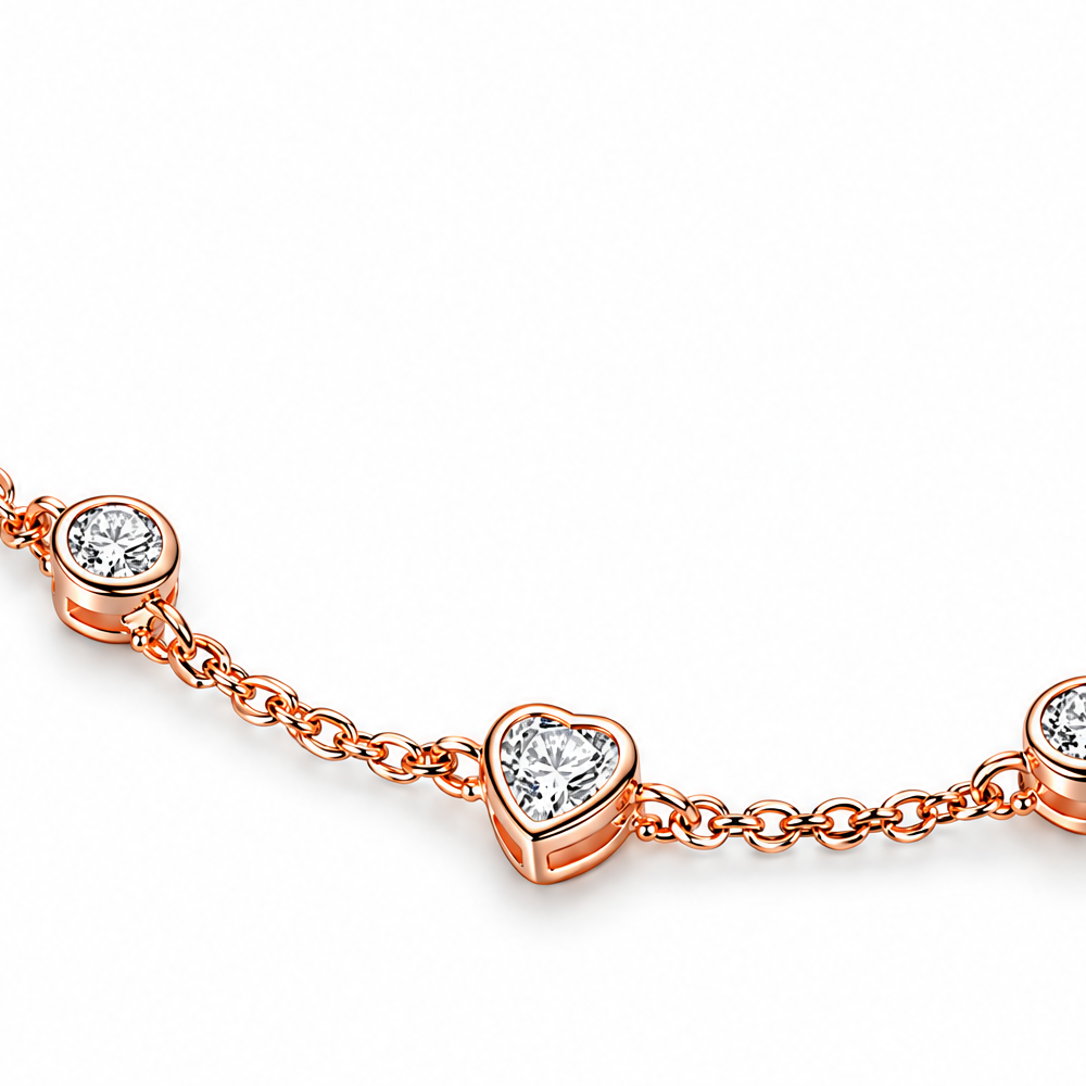 Rose Gold Plated bracelet heart-station detail crop with clear stone and linked chain on white.