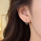 The Kiri Huggie Hoops — Silver huggie — on-ear side-front view; reference-based AI visualization