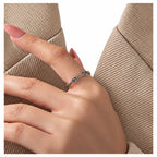Sterling Silver curved starburst band ring with dark accents, worn on the same hand with neutral ribbed clothing against a seamless white studio; studio edit and AI enhancement of the existing worn view.