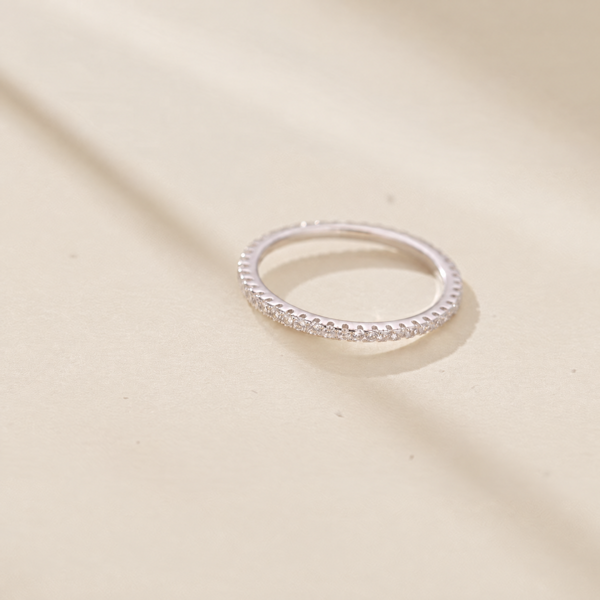 The Vale Eternity Band — low horizontal cream-studio; AI-enhanced supplier view