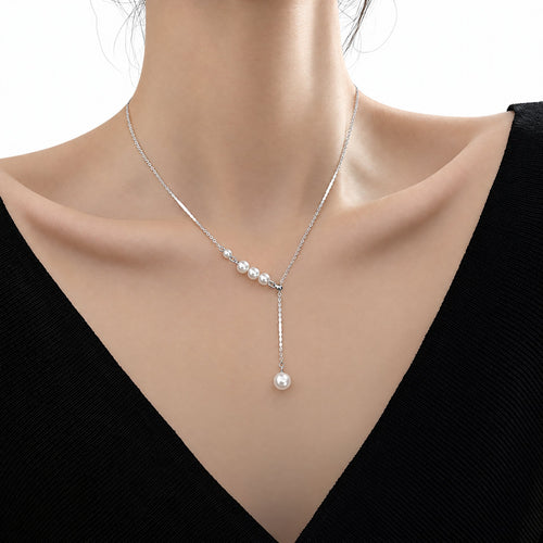 Sterling Silver pearl-drop necklace worn at the neckline with white bead accents in a pure white studio setting with soft natural shadows; studio edit and AI enhancement of the existing faithful supplier-source crop, with necklace ends outside the frame.