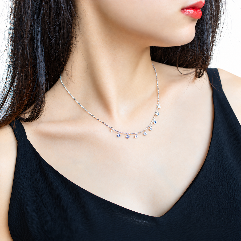 The Astrid CZ Link Necklace — silver-tone CZ charm necklace worn front view in white studio; AI-enhanced supplier view.