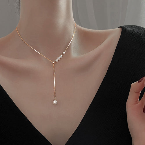 Gold Tone pearl-drop necklace worn at the neckline with white bead accents; faithful supplier source crop, with necklace ends outside the frame.